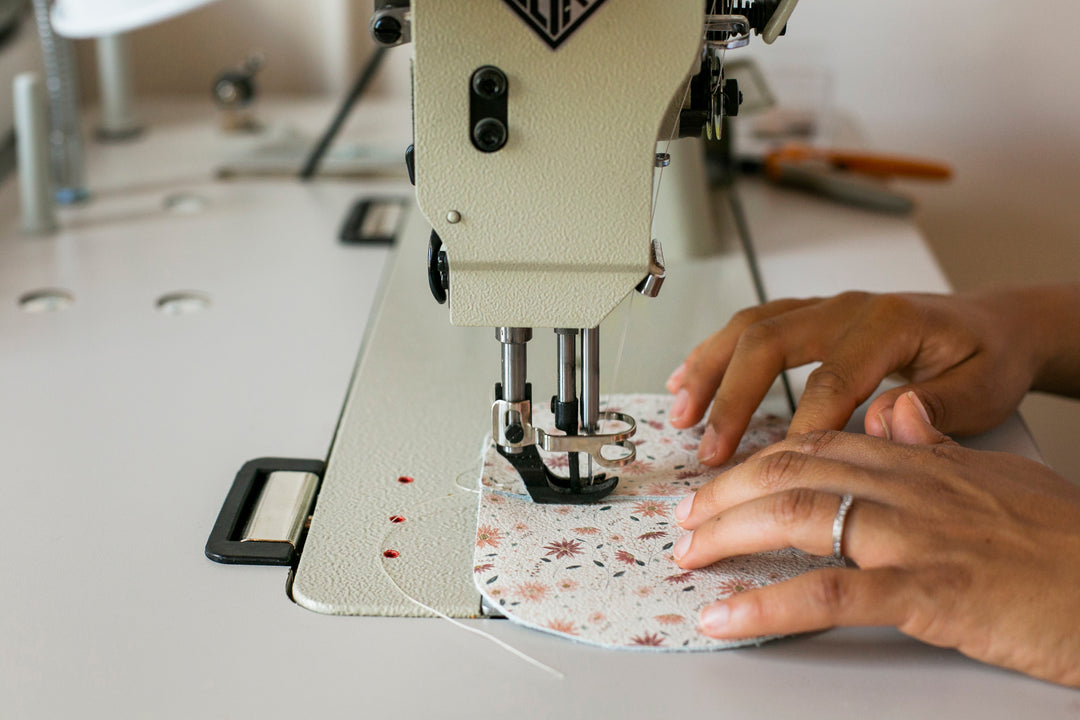 hands sewing leather on sewing machine